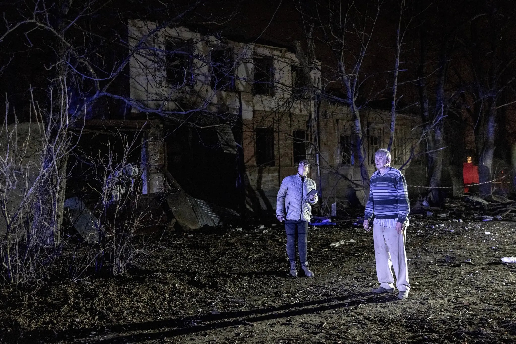 Мирні мешканці Харкова, північно-східного українського міста, оглядають місце атаки безпілотника у березні.